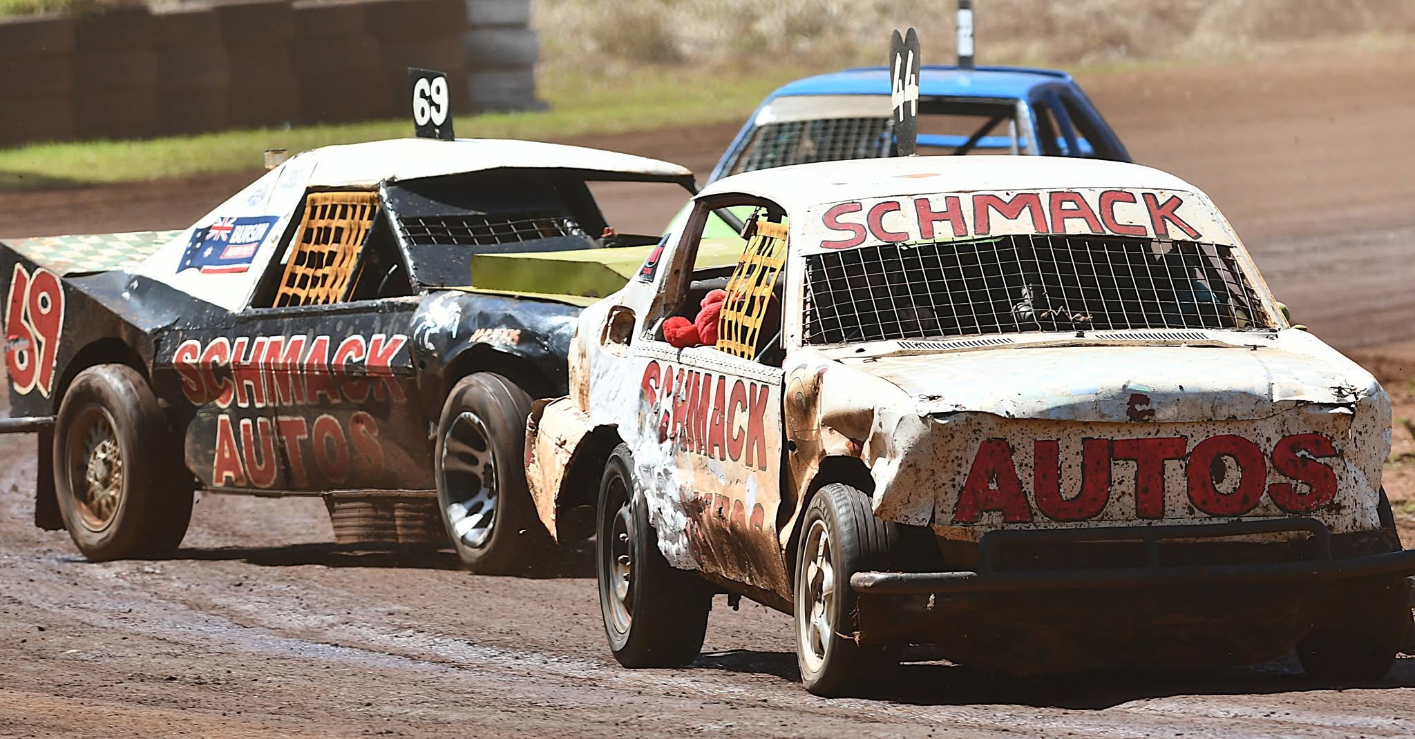 Two Schmack Autos race cars side by side on a dirt oval
