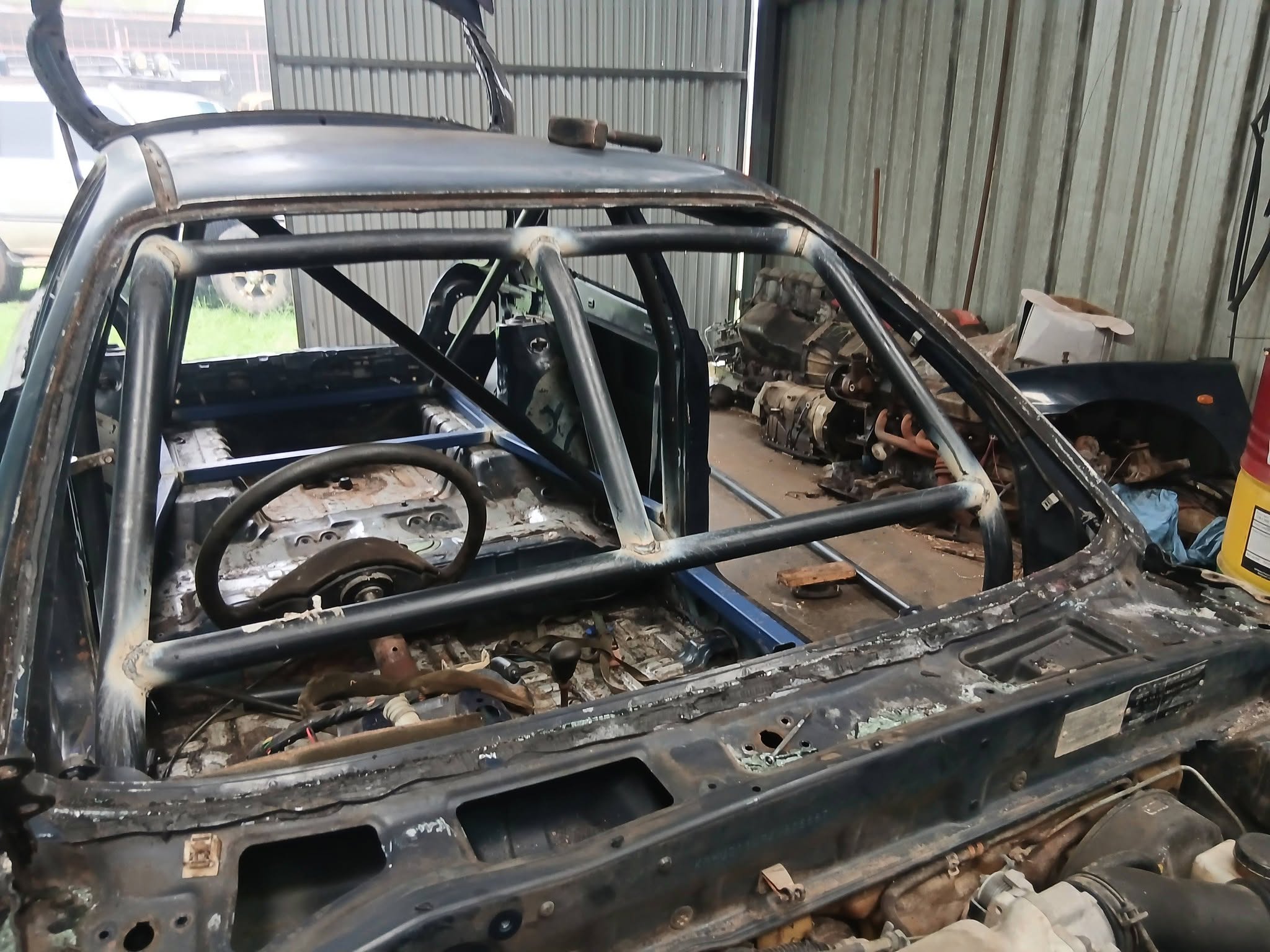 Car shell with a welded steel roll cage inside the Schmack Autos workshop